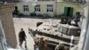Ukraine -- Fighters of Ukrainian national guard's paramilitary Donbass battalion walk in a schoolyard after a fight with separatist militants in Ilovaisk, some 50km from Donetsk, Ukraine, 26 August 2014. 